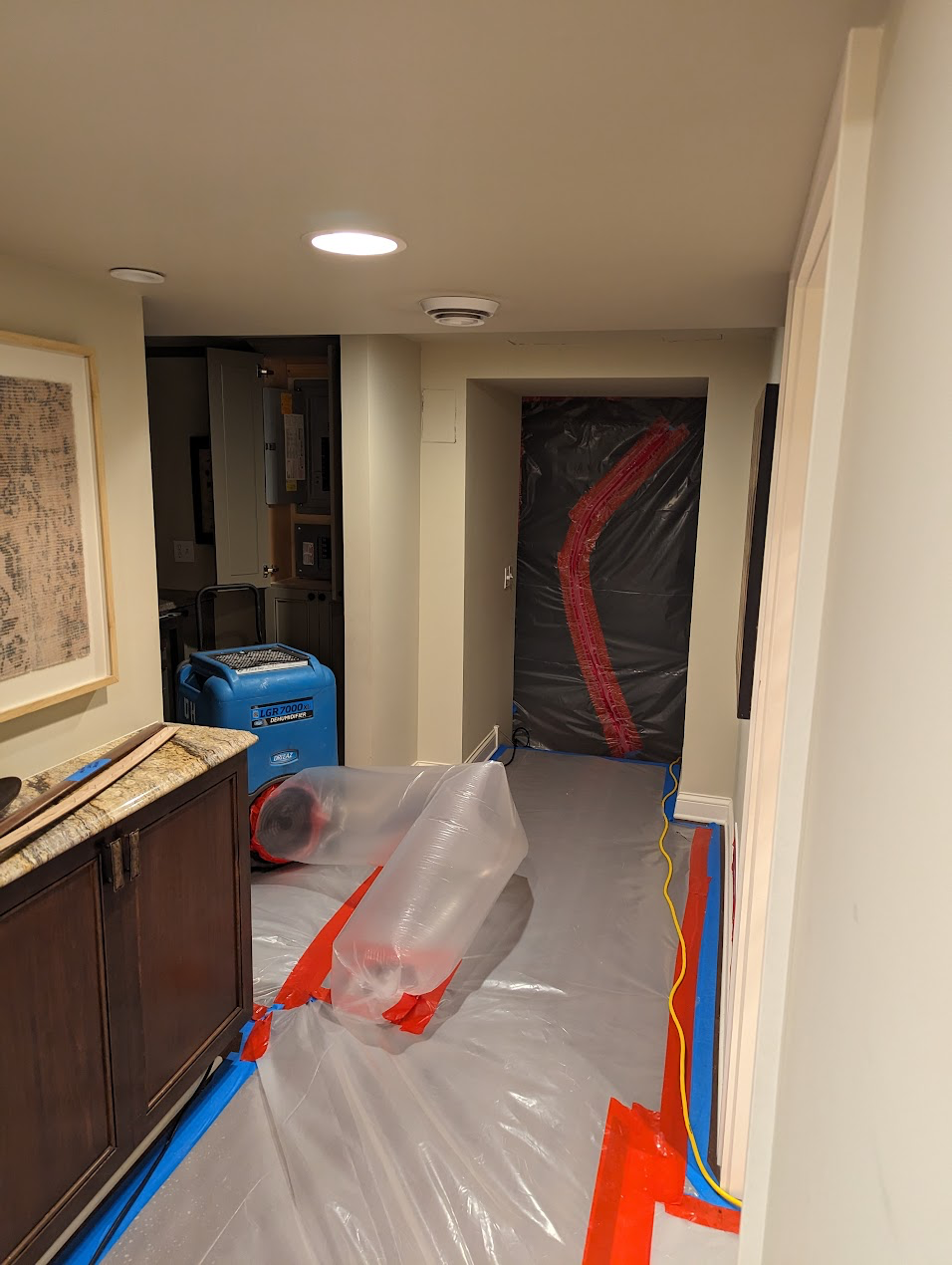 Containment barriers and plastic sheeting set up in a hallway during mold remediation